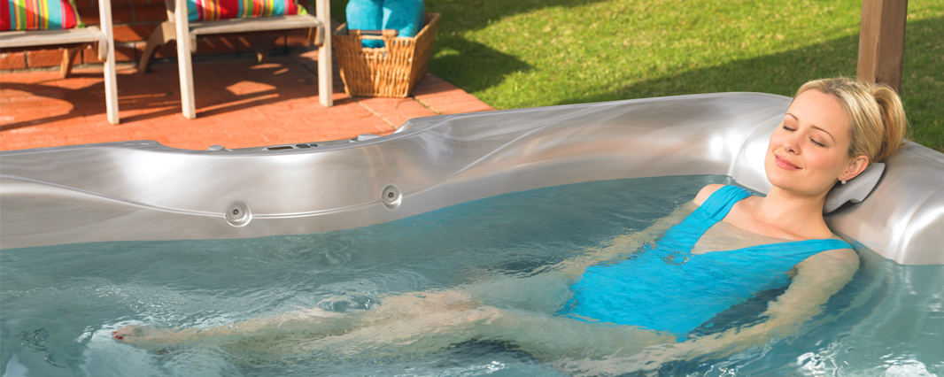 Woman laying and relaxing outside in hot tub