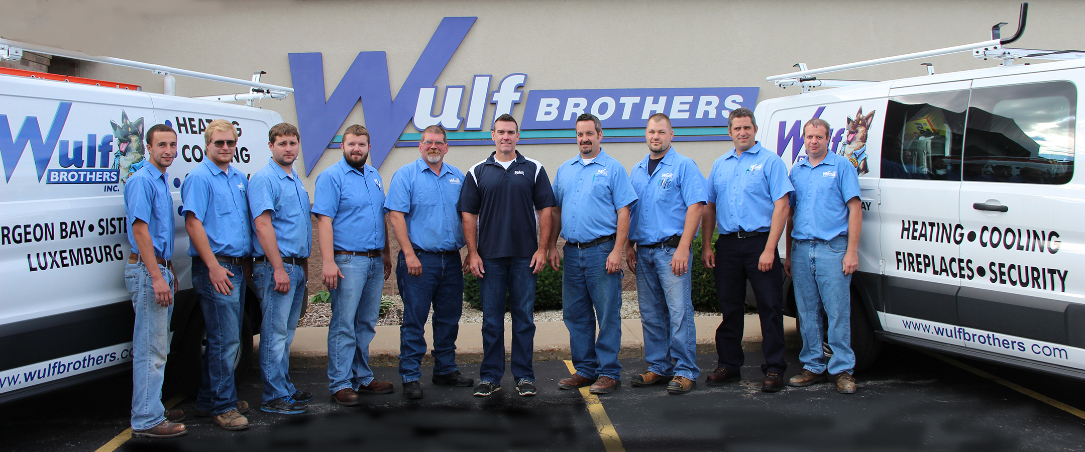 Wulf Brothers team standing next to installation trucks